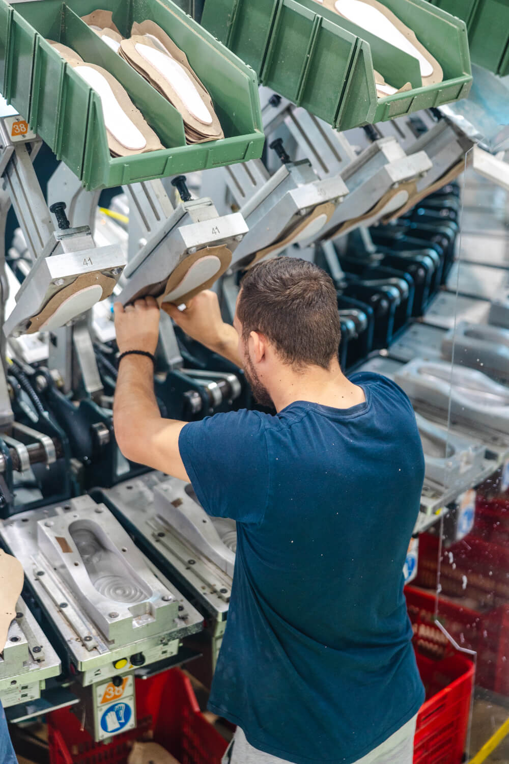 Worker at sole pressing carousel